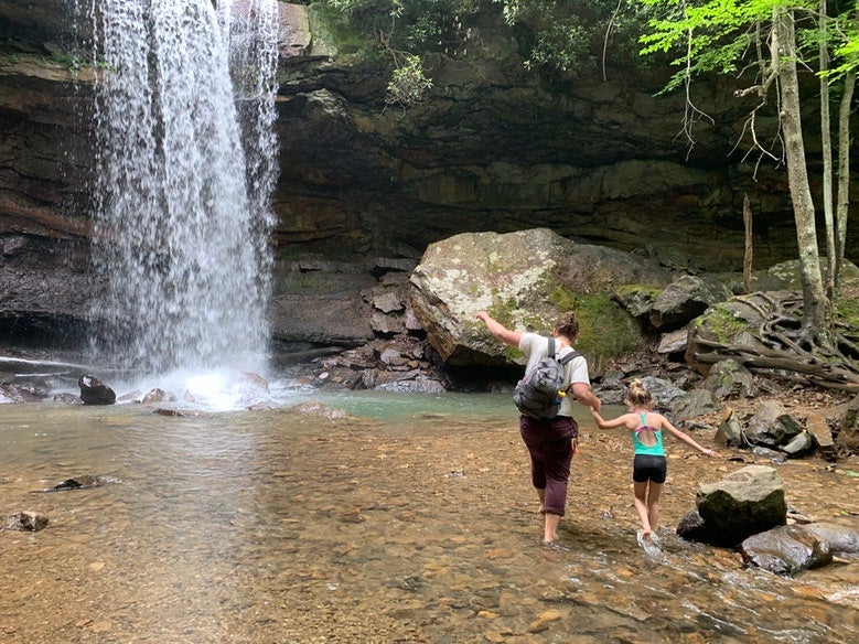 mother and daughter balance on rocks near waterfall in Ohiopyle State Park, photo from a camper on The Dyrt