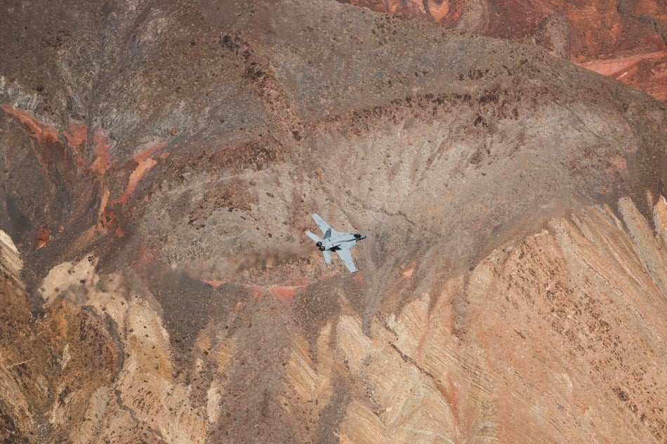 a jet flying through a red canyon