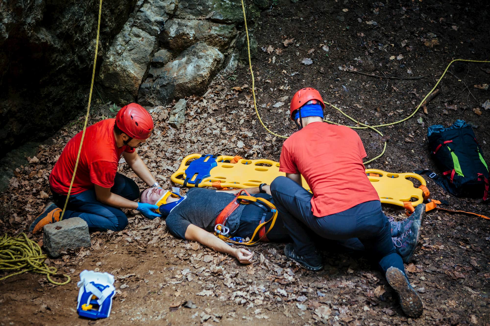 Search and rescue alpinists setting up an immobile person on a stretcher.