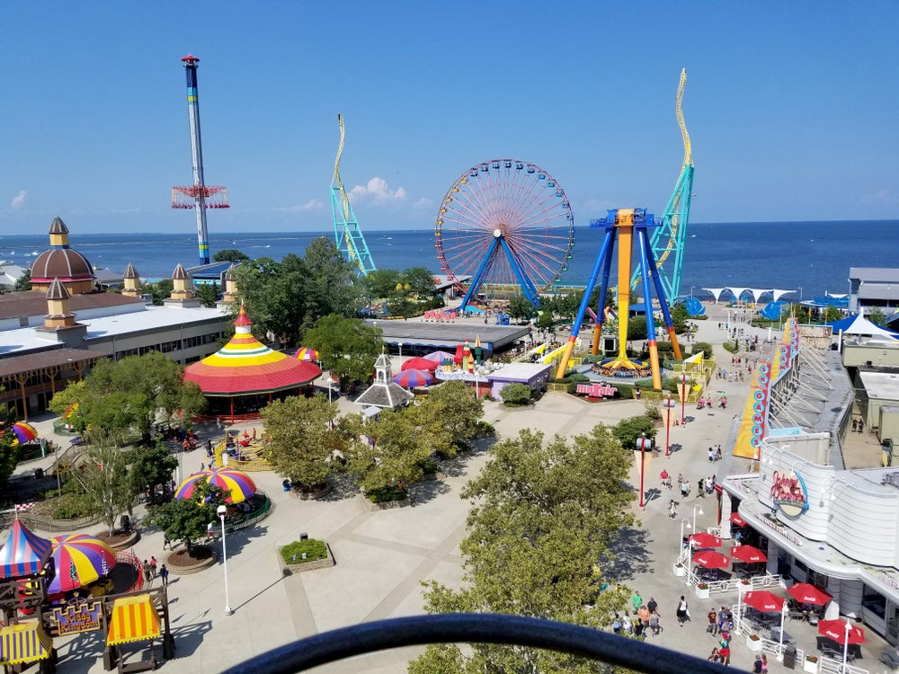 Ferris wheel and other rides at amusement park with lake in background
