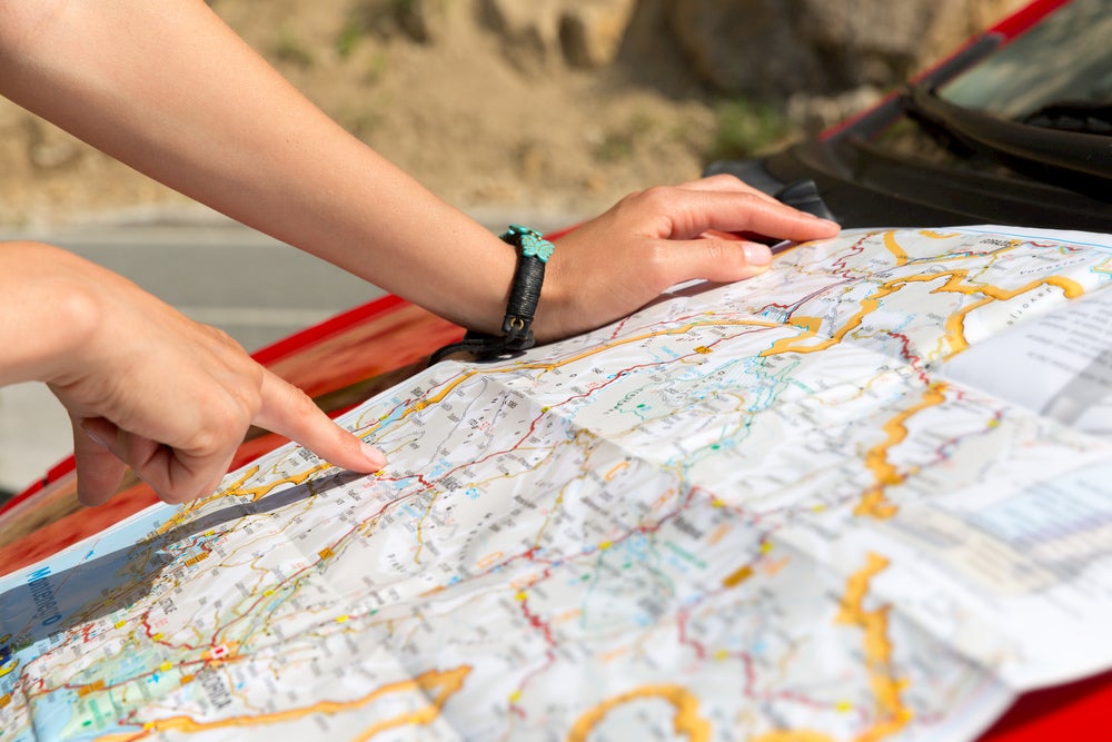 Person reading map outside.