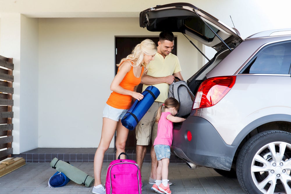 Family packing up car for a trip.