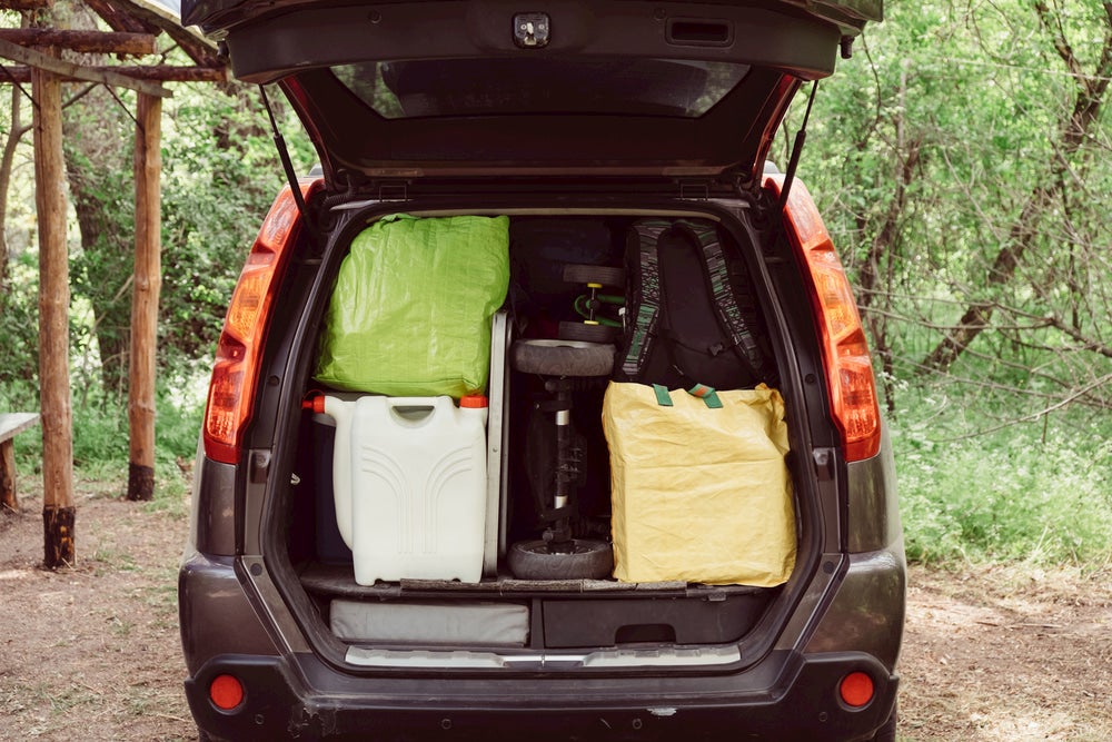 Car packed up with camping gear and a water jug.