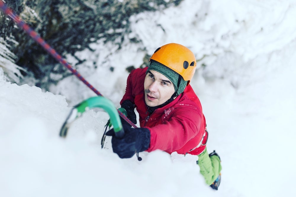 a man climbing close up on ice in alpine conditions
