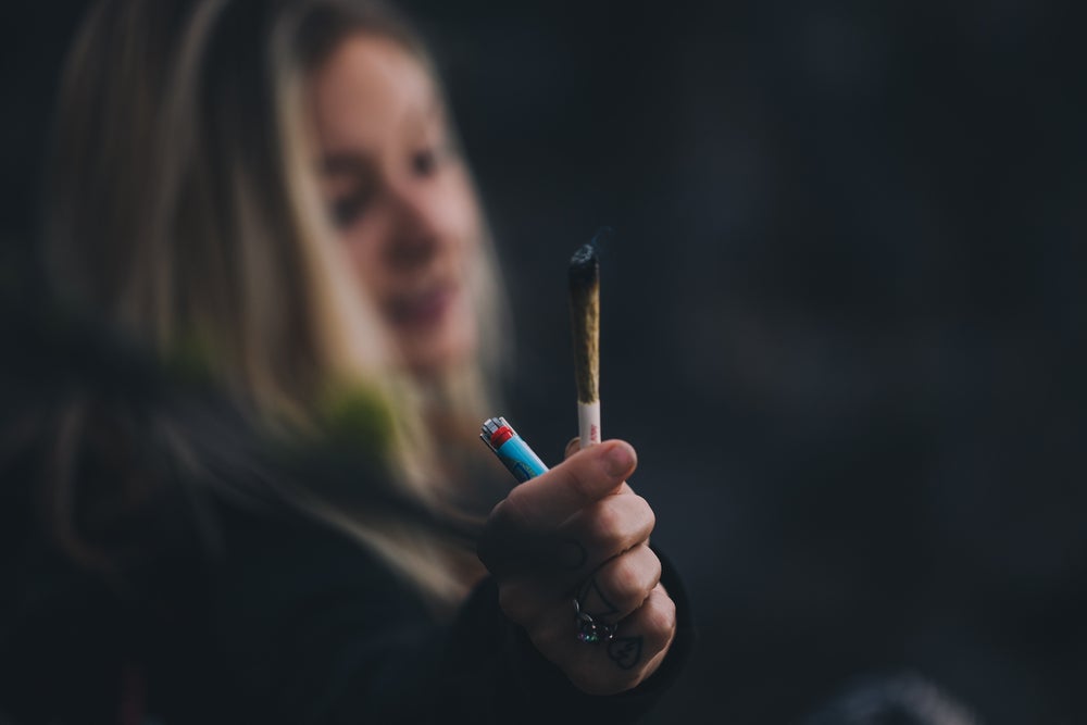 a woman holding a joint and a lighter