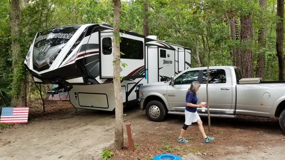 woman crosses in front of her large RV campsite in Myrtle Beach State Park, photo from a camper on The Dyrt