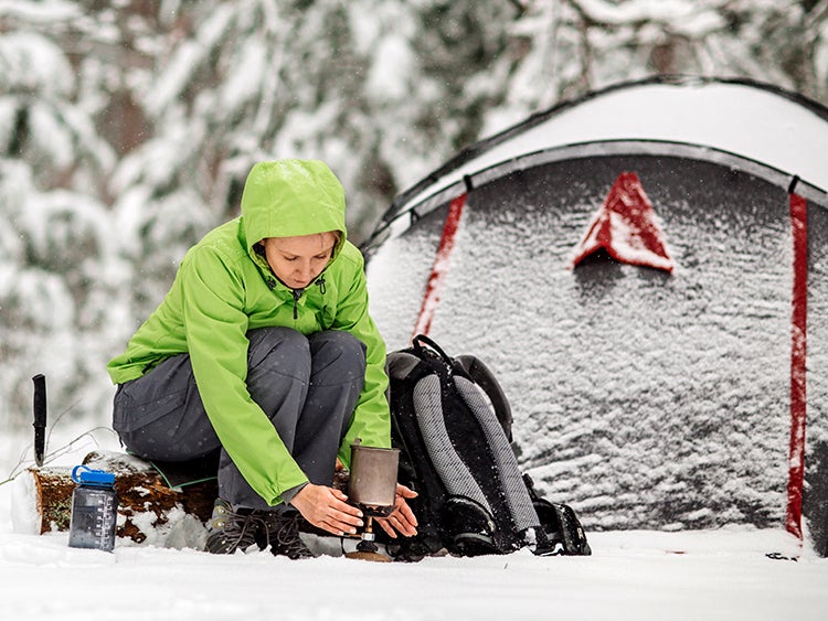 woman survival camping in winter snow