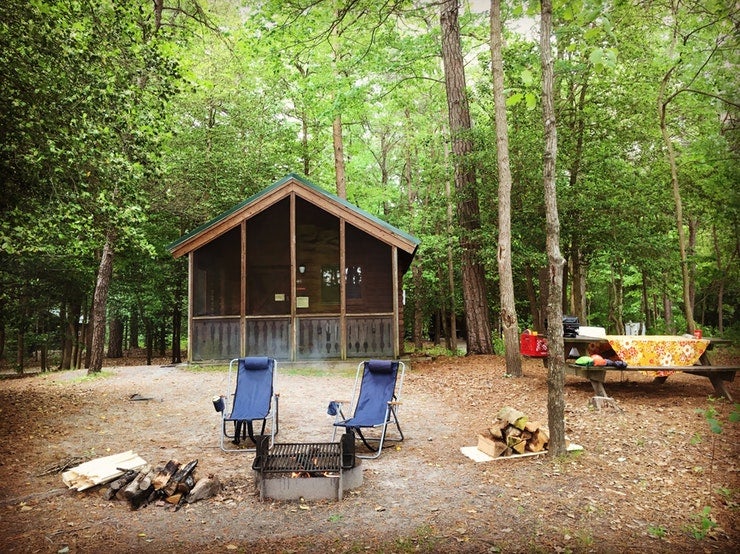 camp chairs set up between camp fire and cabin at Delaware's Trap Pond State Park, photo from a camper on The Dyrt