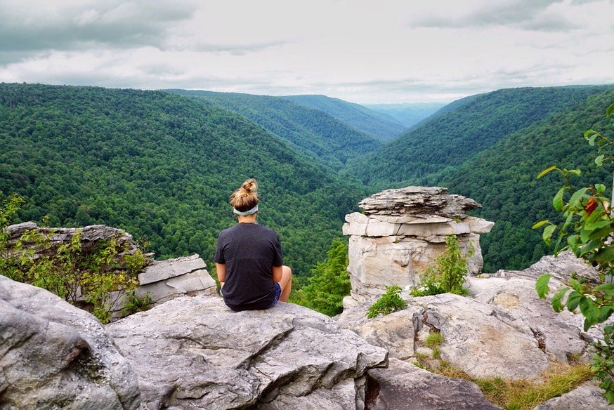 female hiker rests on rocky overlook at West Virginia's Blackwater Falls State Park, photo from a camper on The Dyrt