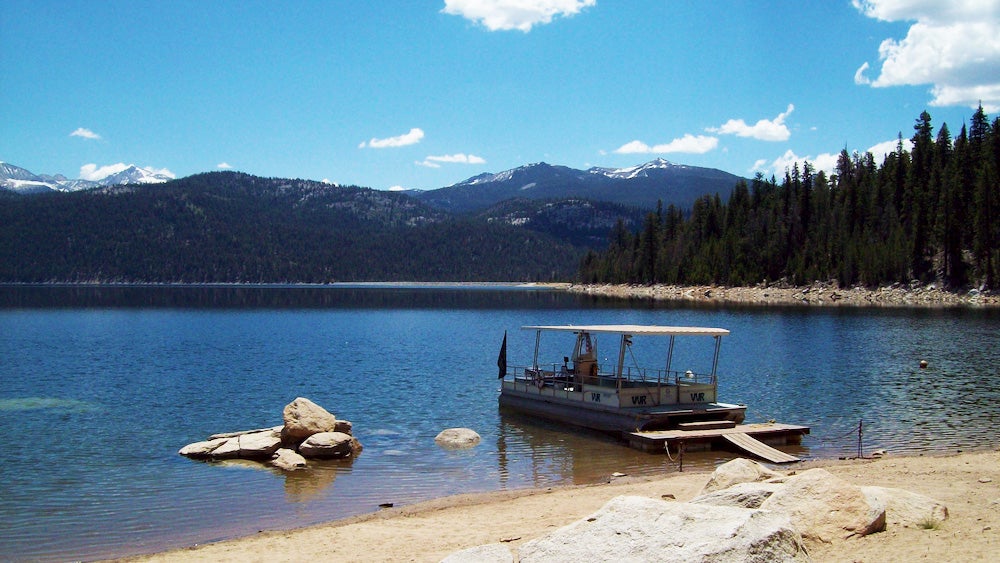 Boat in lake along John Muir Trail with mountain in background 