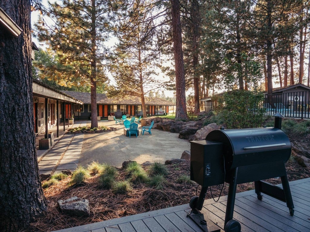 a loge hotel deck with a grill in the woods
