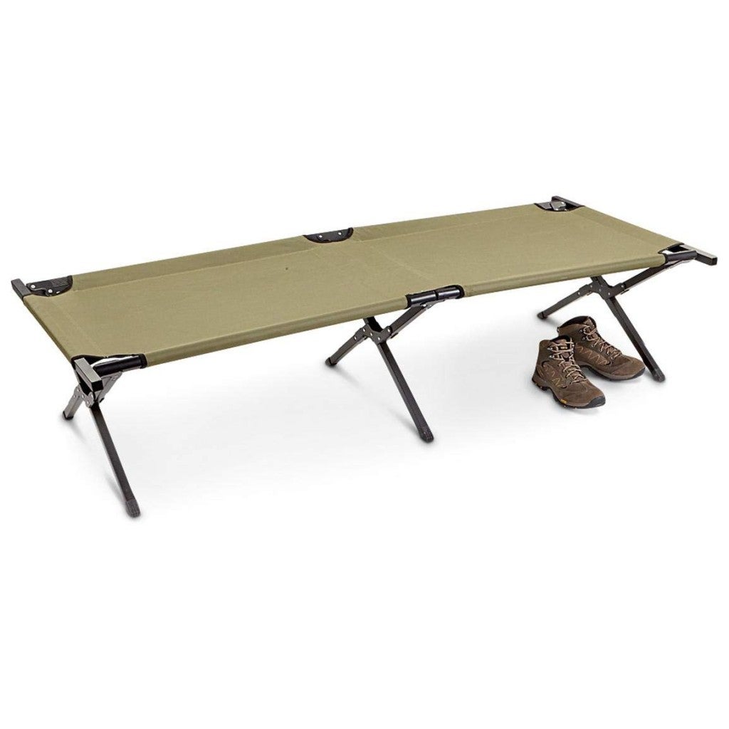 a green army cot with a pair of boots