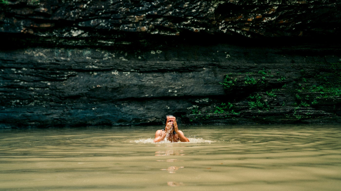 Man washing his beard while swimming in a lake.