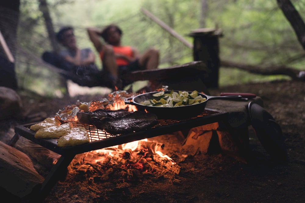 Food on a grill with people in background 