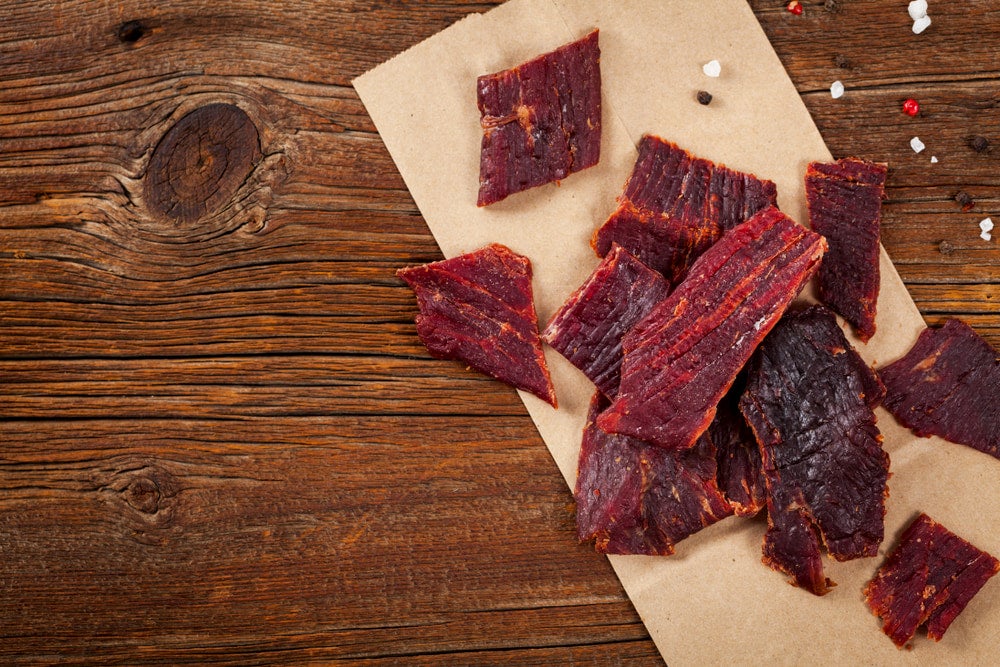 Slices of beef jerky on wood 