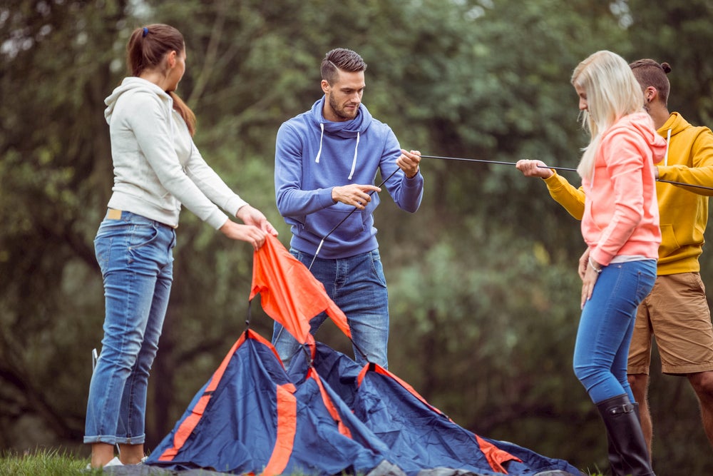 People working together to set up a tent.