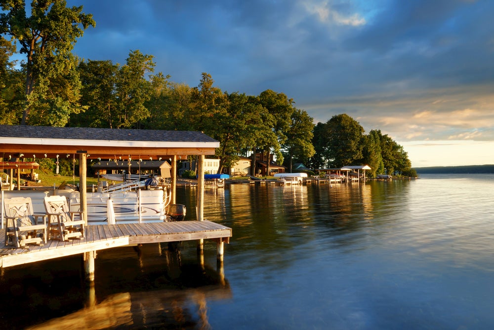 Houseboats on water with trees and stormy sky in background