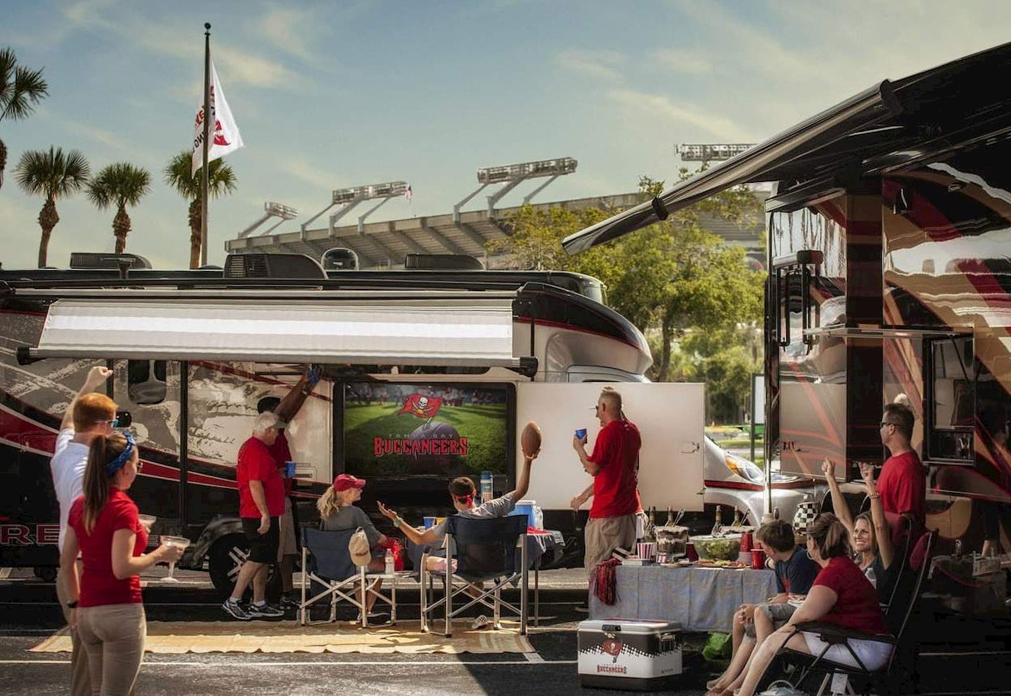 Group of tialgaters watching a t.v. in their RV outside of the stadium.