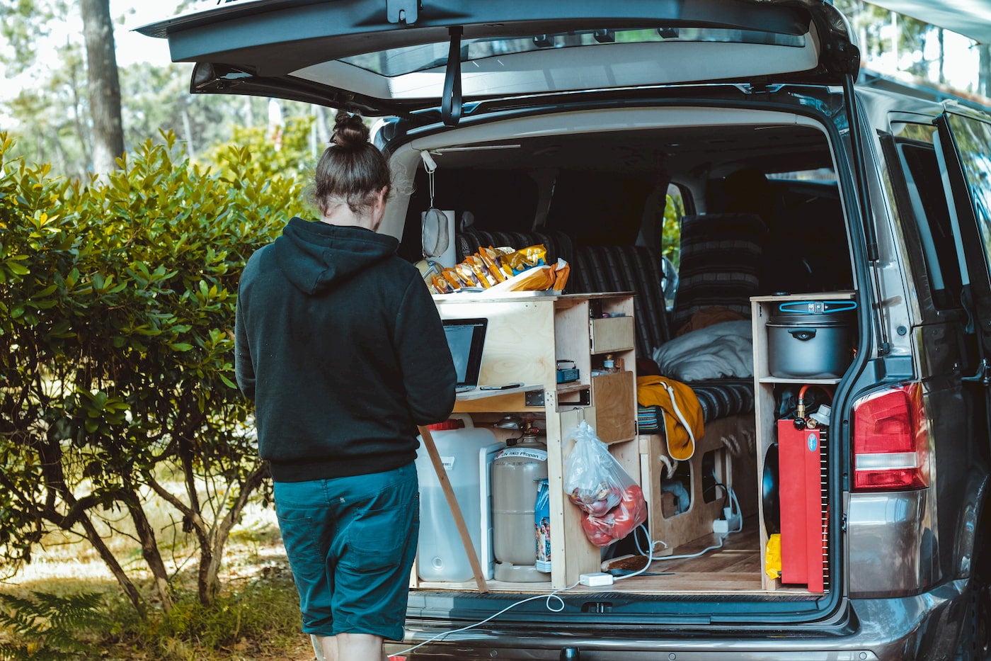 Van life camper using their laptop in the kitchenette.