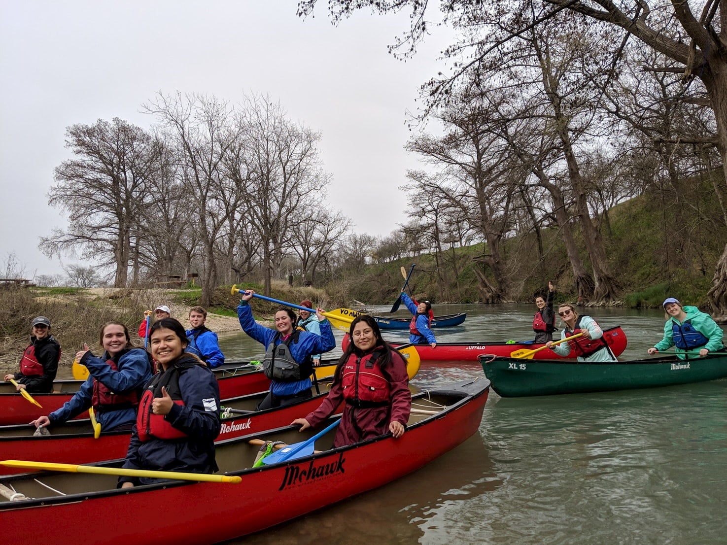 Group of people canoeing on the San Marcos river.