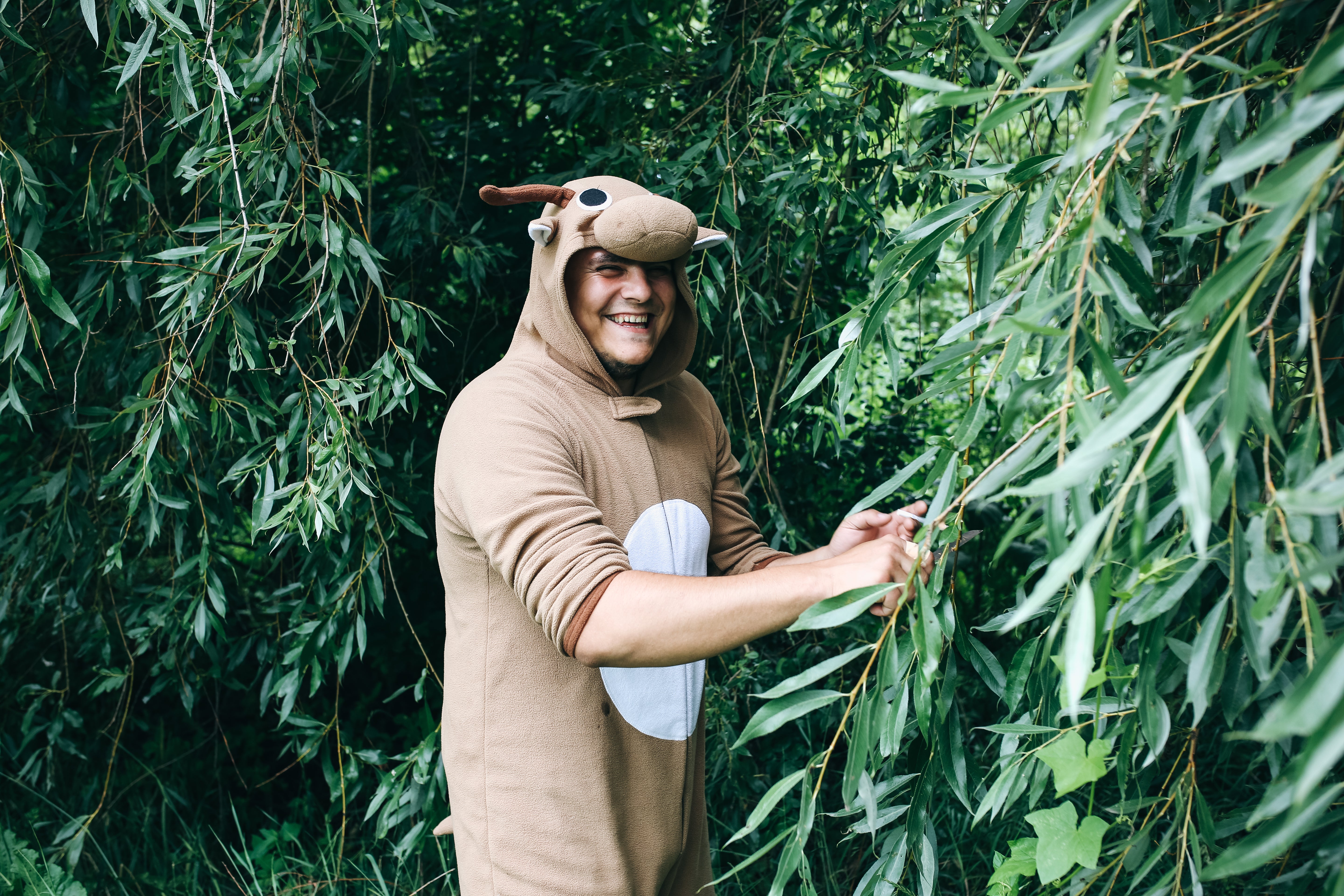 Guy in a deer costume in the forest.