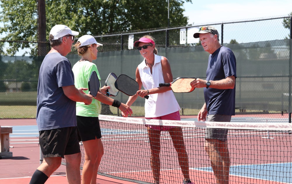 four people playing pickleball on a court