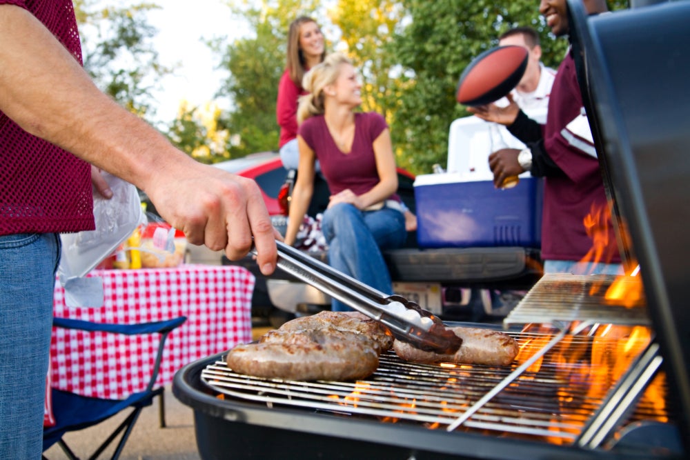 People grilling at a football tailgate.