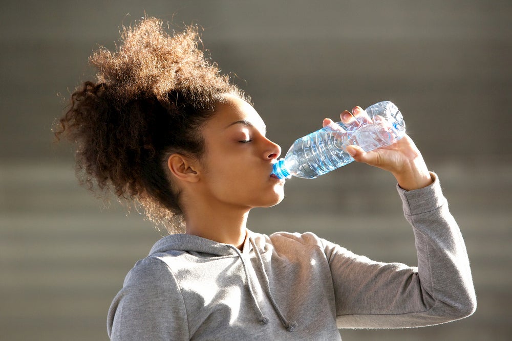 Women drinking water post workout.
