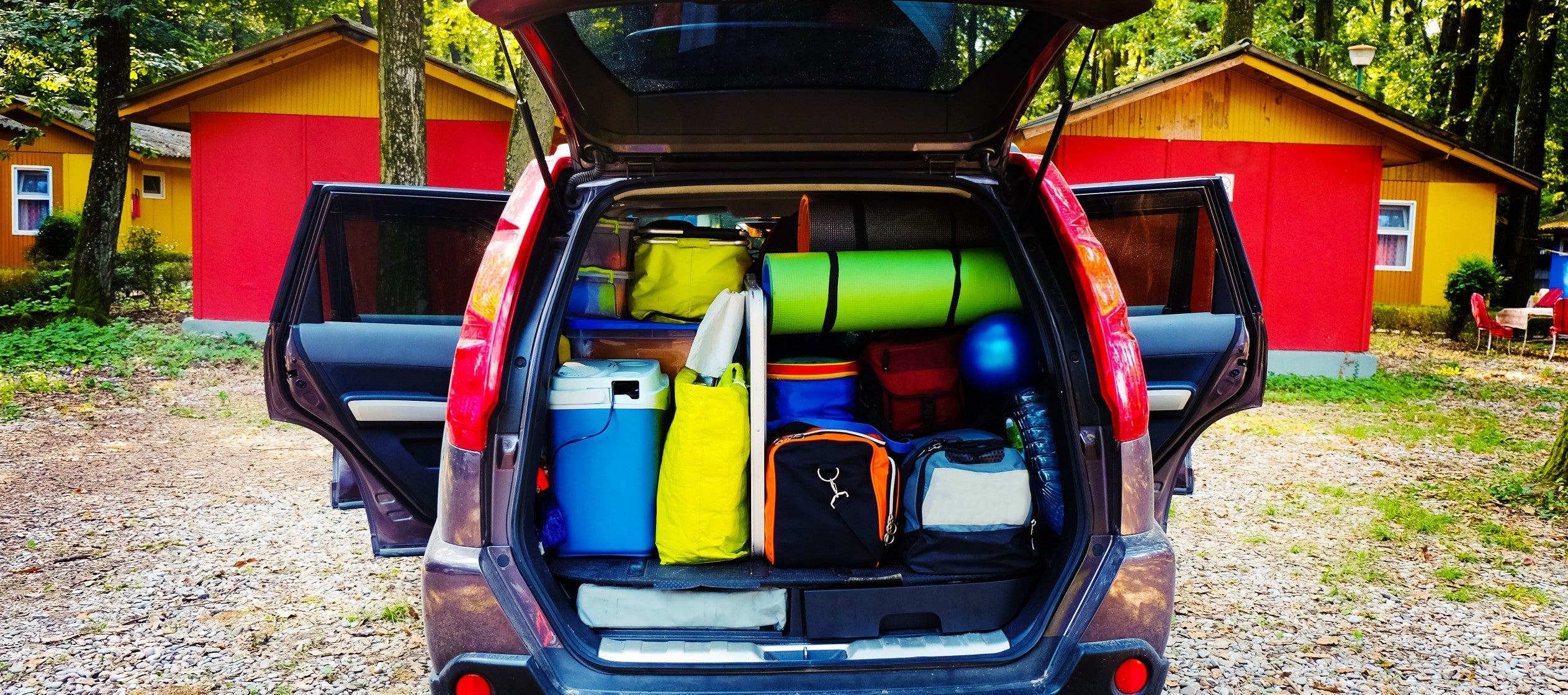 back of car with trunk open, full of camping gear