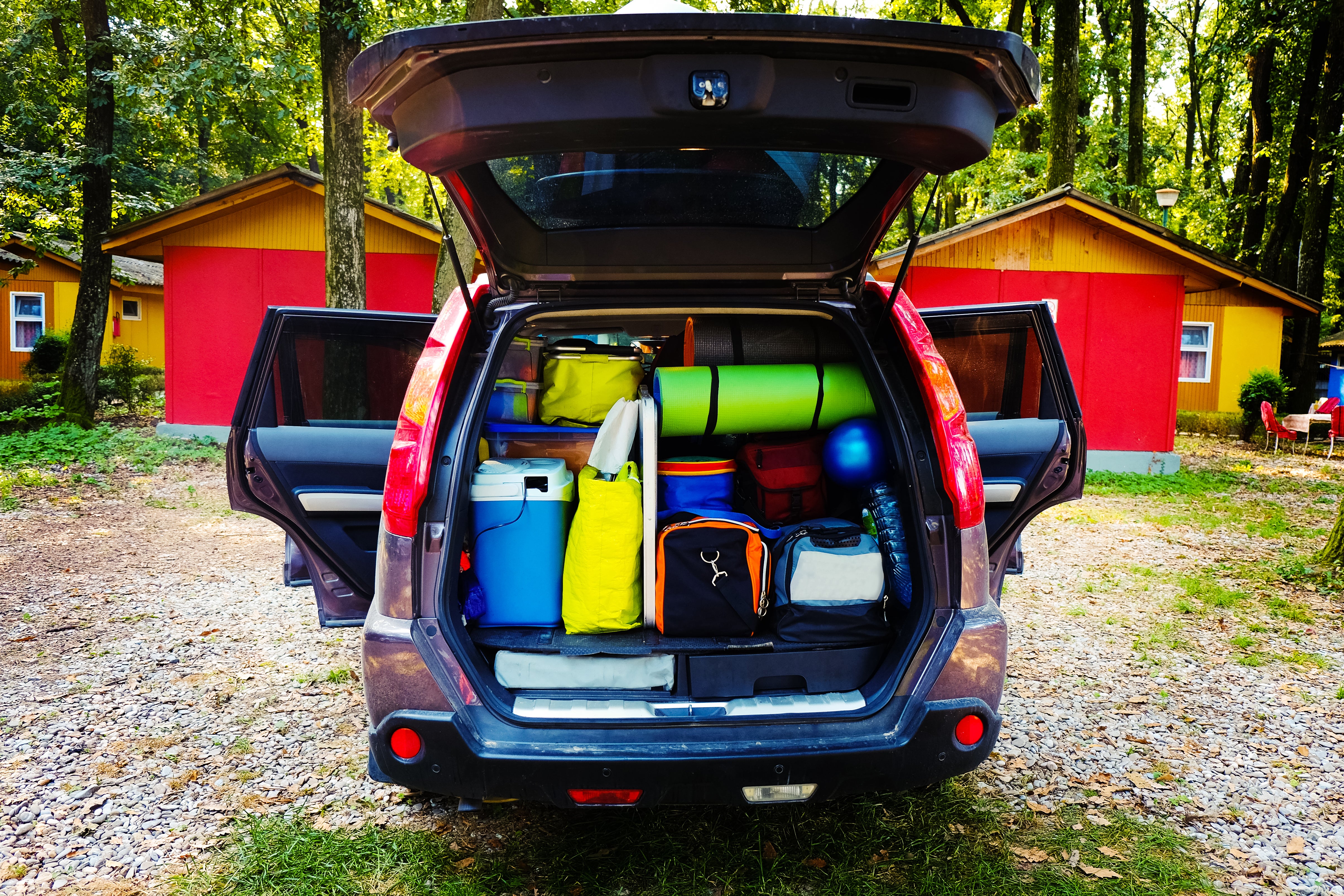 back of car with trunk open, full of camping gear