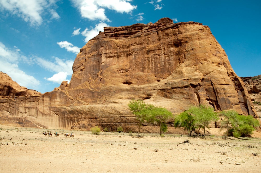 Horse back riders on the Canyon de Chelly floor.