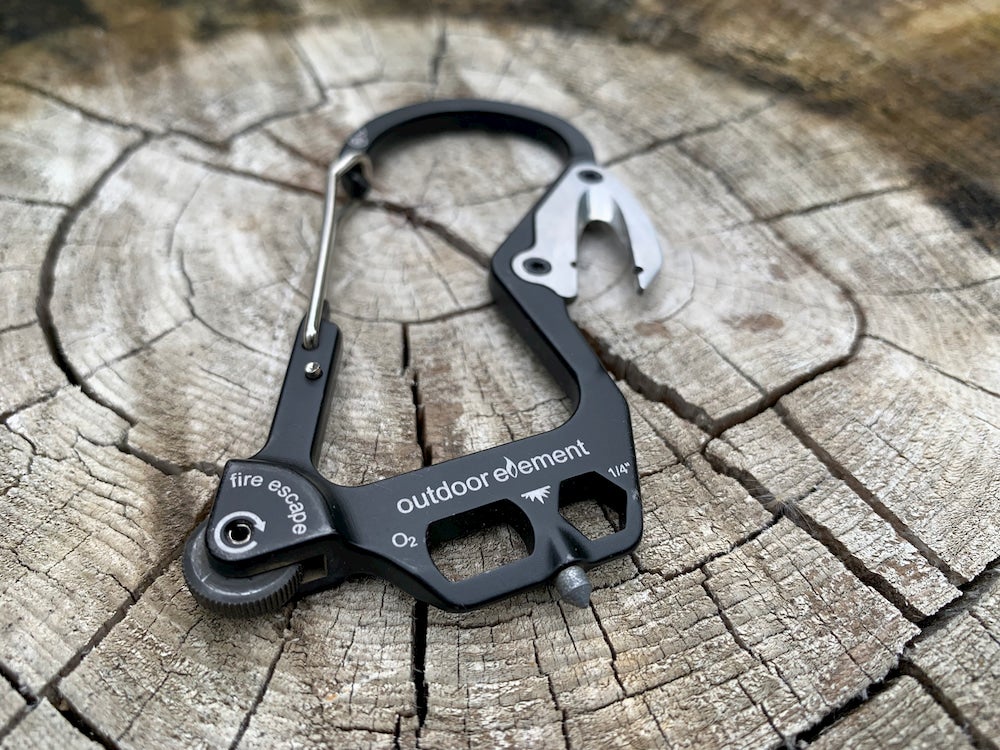 a fire escape carabiner on a log