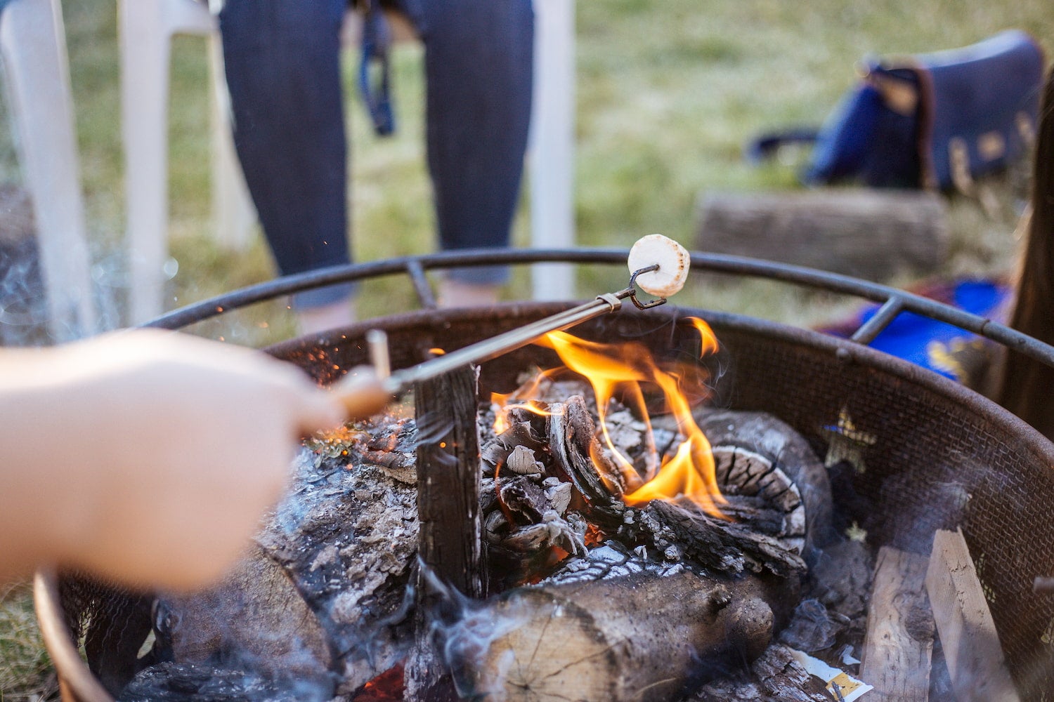 Person roasting marshmallow over a fire.