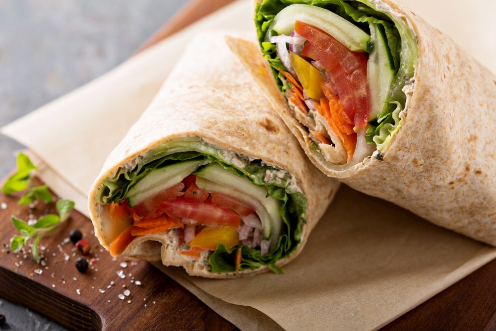 Veggie wrap on a wooden platter.