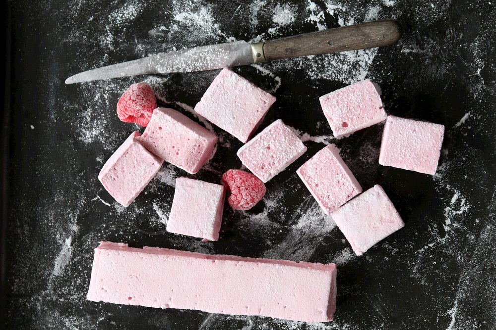 Pink homemade marshmallows cut into squares,