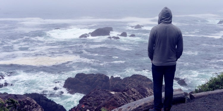 Person looking out at the ocean on a stormy day.