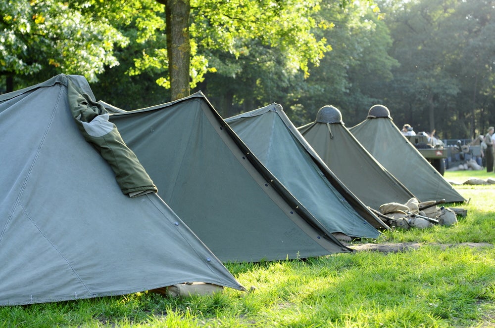 Military campsite with green canvas tents.