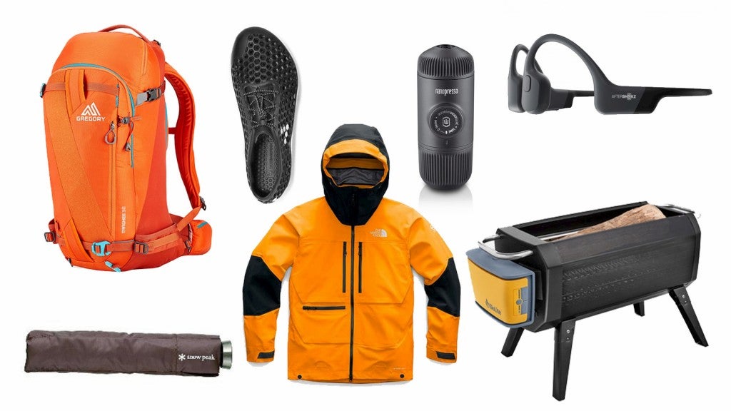 Flat lay of gear: shoes, jacket, umbrella, headphones .