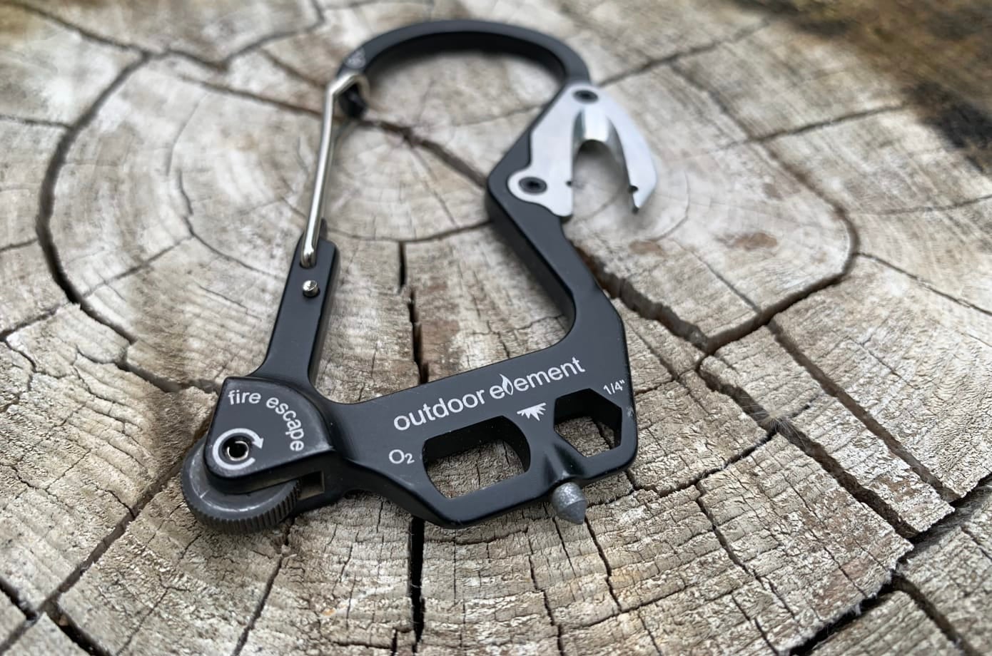 Carabiner multi-tool on log.