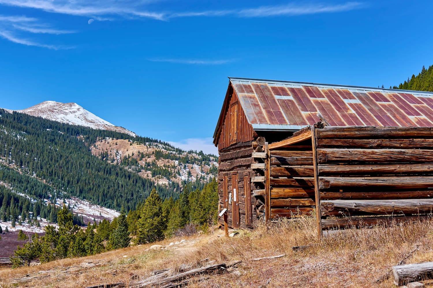 abandoned cabin with mountain peak in the background