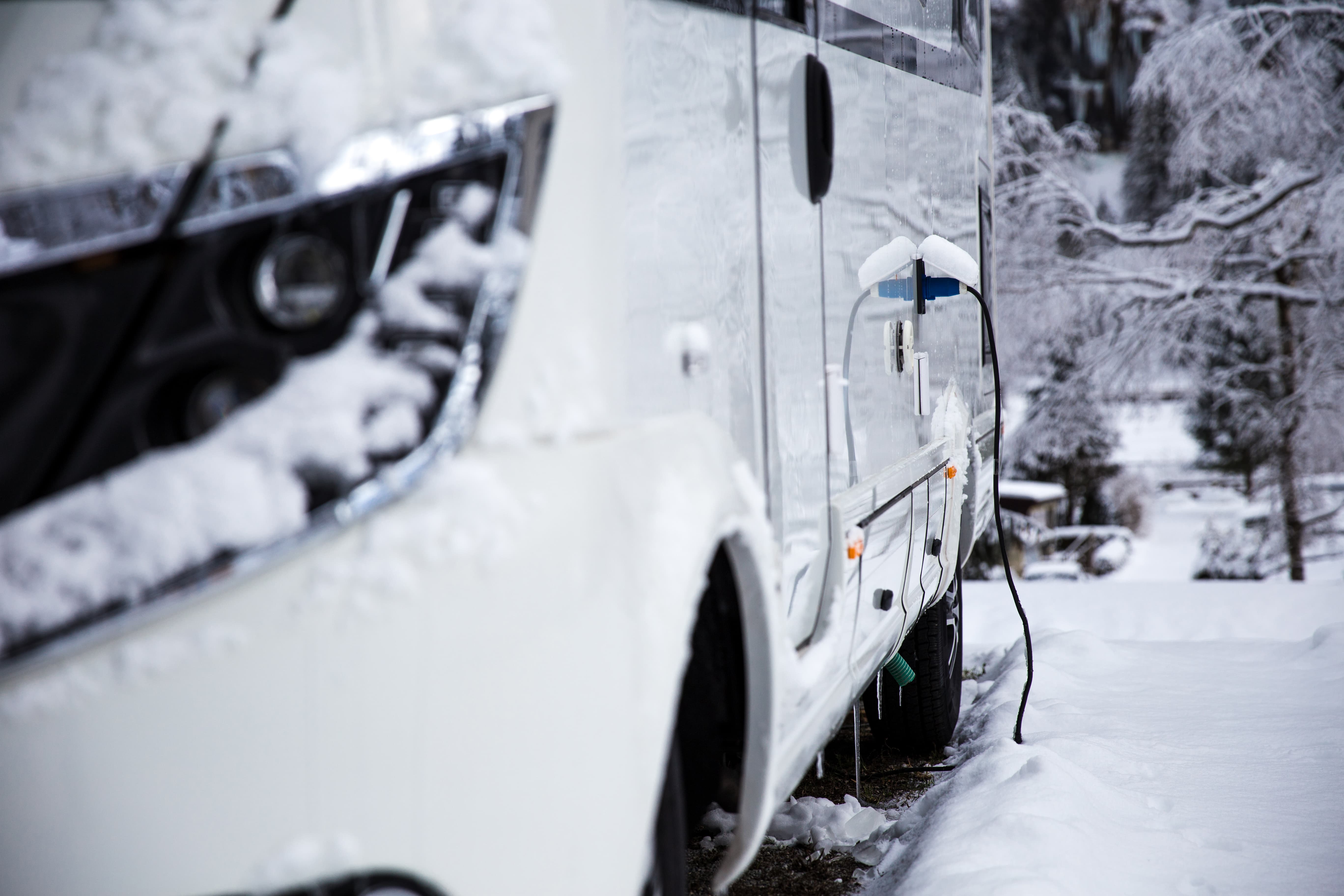 rv camped in the snow with electric input plugged in