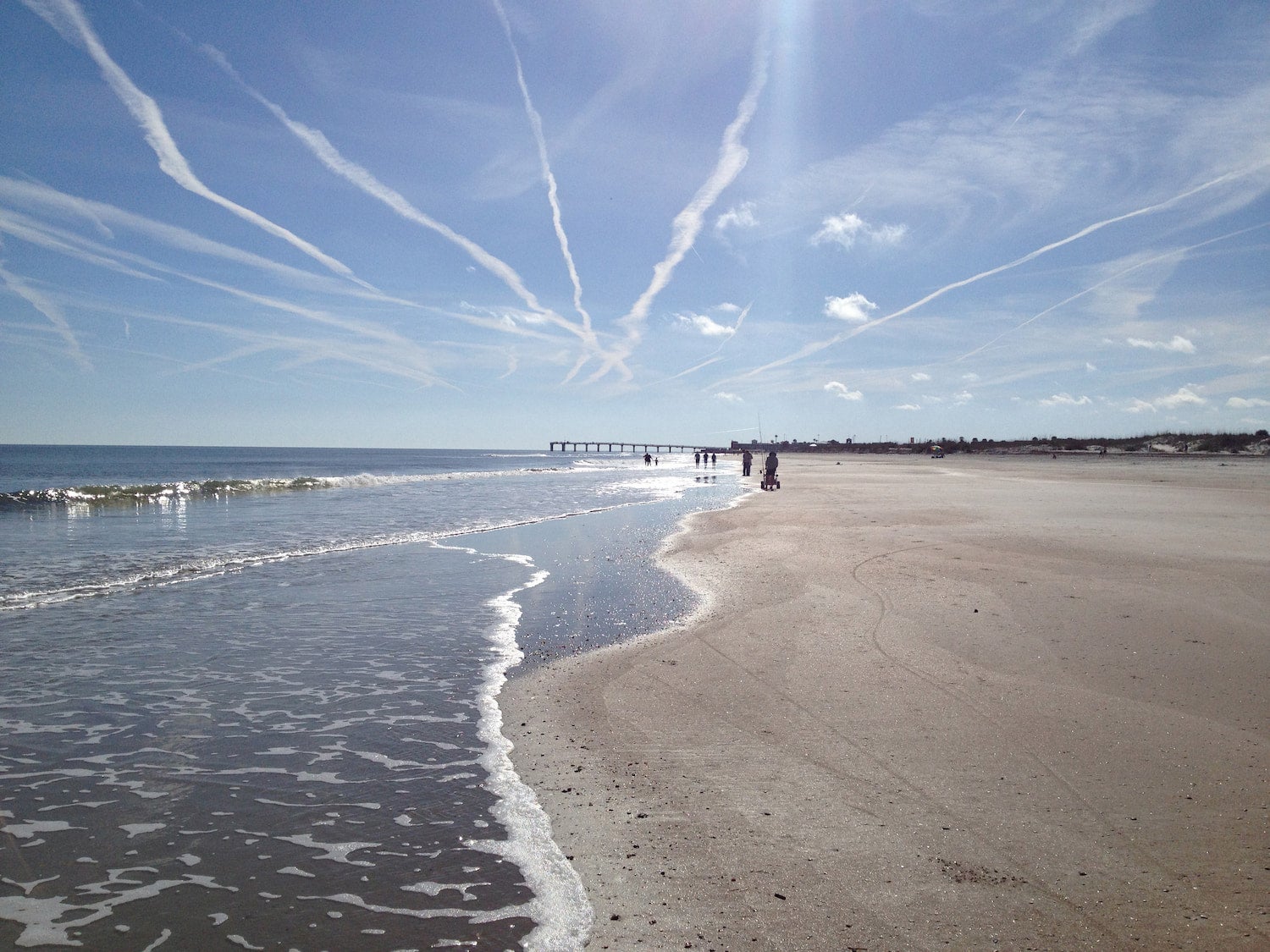 white beach with lowtide and pier far in the background