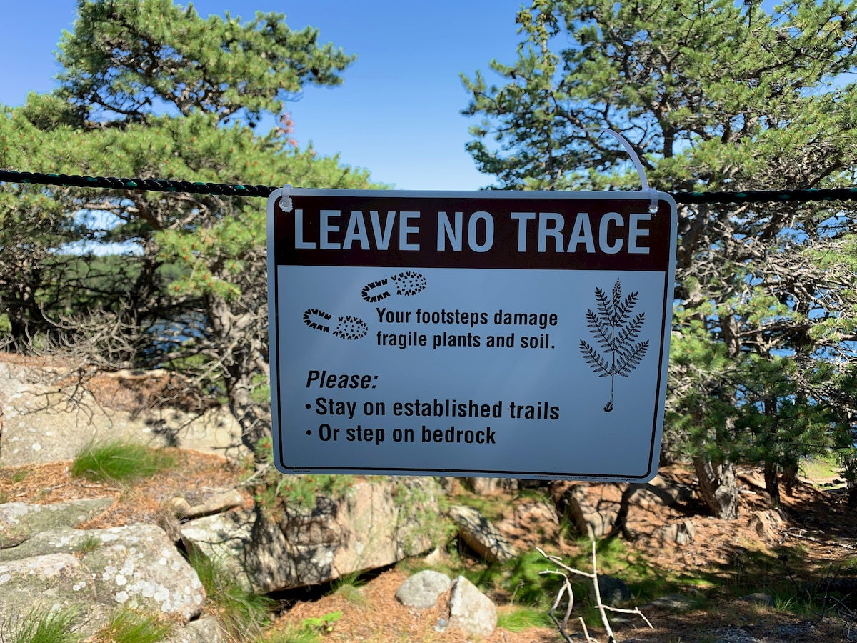 Natural landscape with a leave no trace sign in front of it.