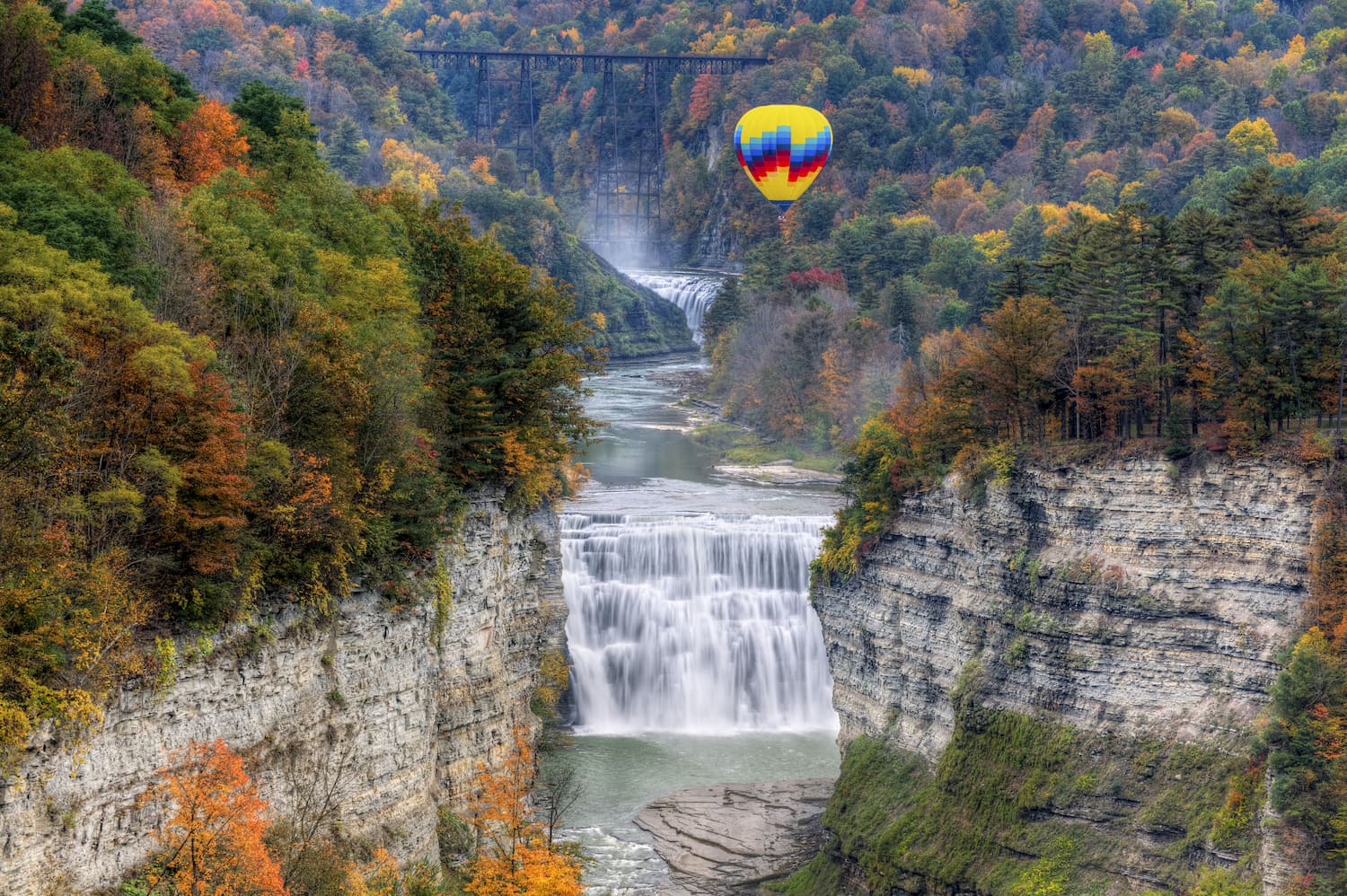 hot air balloon over waterfall at middle falls at letchworth state park