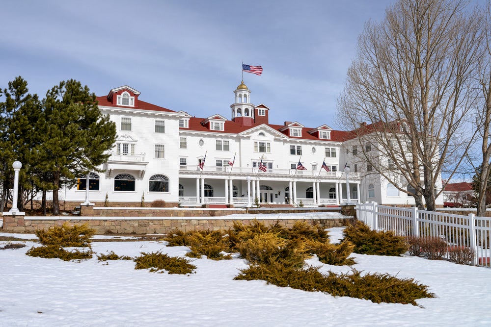 Traditional hotel with a red roof and wrap around porch in the winter.