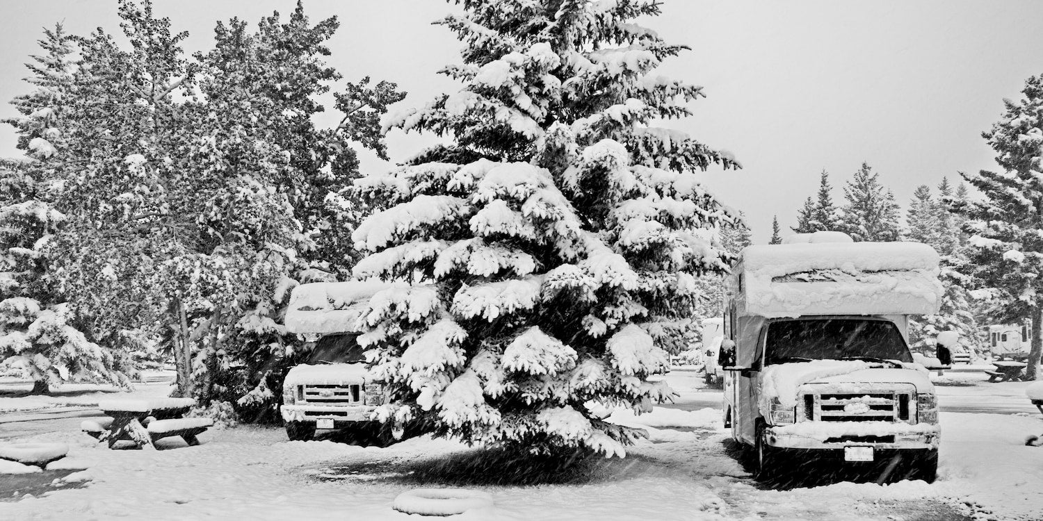 two rvs parked at adjacent snow covered campgrounds