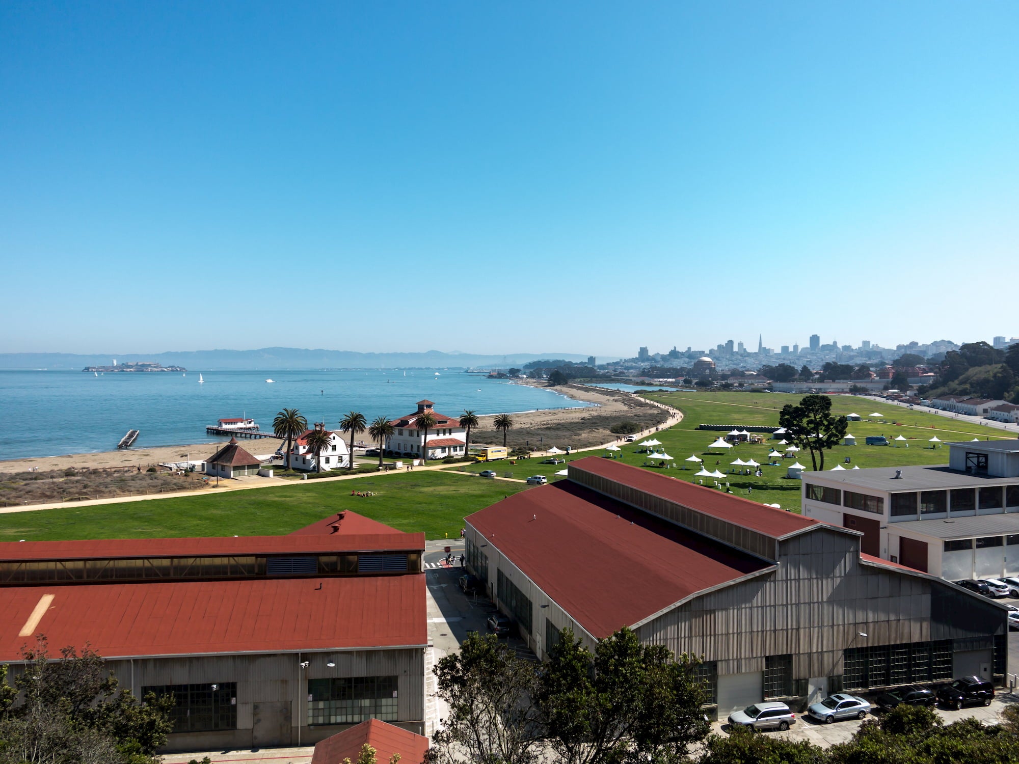 Presidio in San Fransisco, large buildings in foreground and large grass field and ocean in background