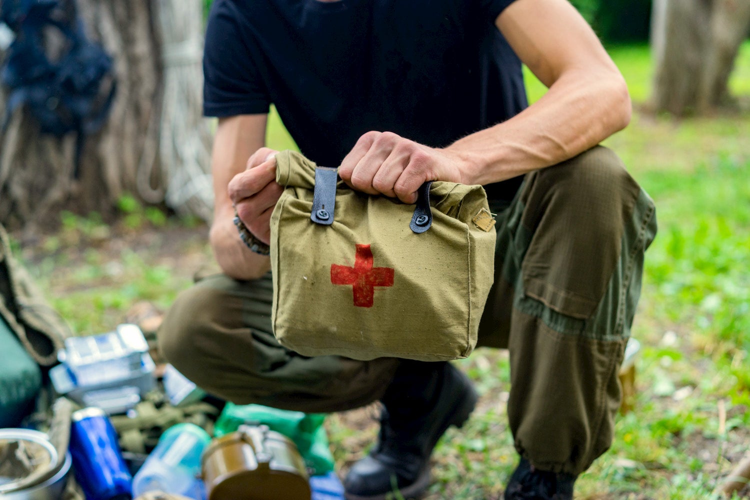 man holding large first aid kit out in the wilderness