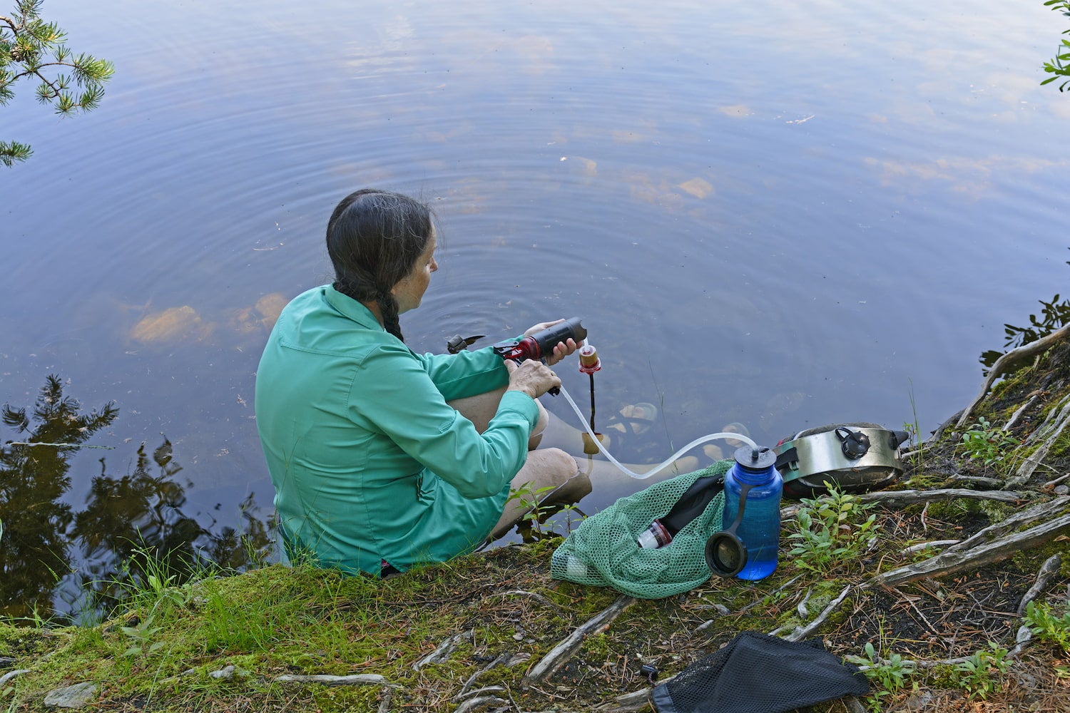 woman filtering water at a body of water