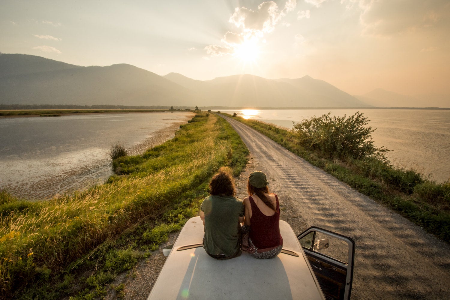 two people on top of a van on a peninsula